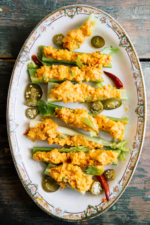Load image into Gallery viewer, slices of celery topped with pimento cheese and garnishes