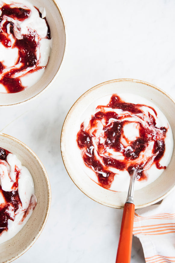 Greek yogurt swirled with bright red strawberry preserves