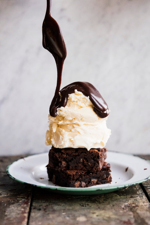 Load image into Gallery viewer, homemade brownies topped with vanilla ice cream and fudge sauce