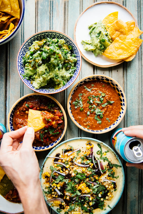 Load image into Gallery viewer, dipping chips into bowls of salsa, queso and guac