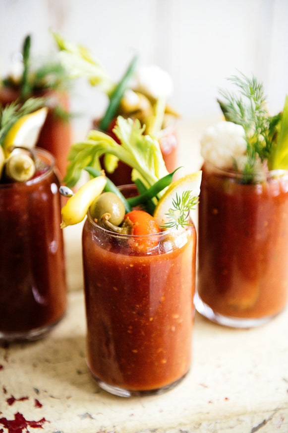 glasses of bloody marys topped with fresh garnishes