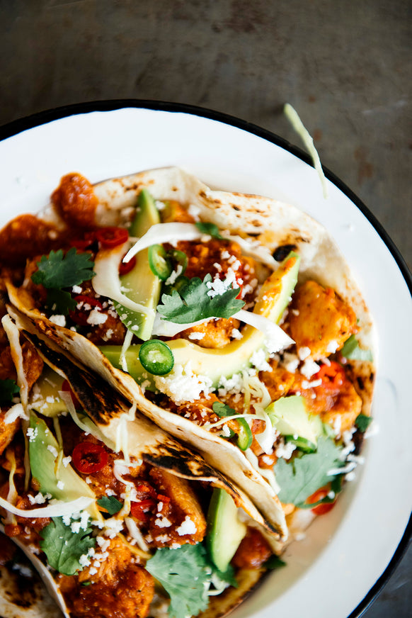 Tacos topped with sliced avocado, and Pumpkin Seed Salsa