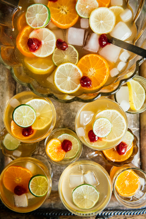 Load image into Gallery viewer, Punch bowl with sliced fruits and ice on a metal tray with served glasses of punch and fruit besides it.