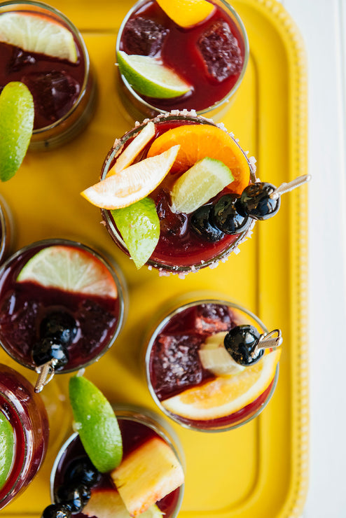 Load image into Gallery viewer, Tray of glasses containing a cocktail made with Cherry Margarita Mix and fresh fruit