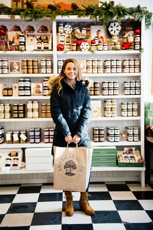 Load image into Gallery viewer, A woman in the Petoskey store with a bag of American Spoon