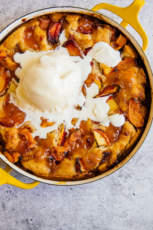 Load image into Gallery viewer, A homemade peach cobbler topped with vanilla ice cream