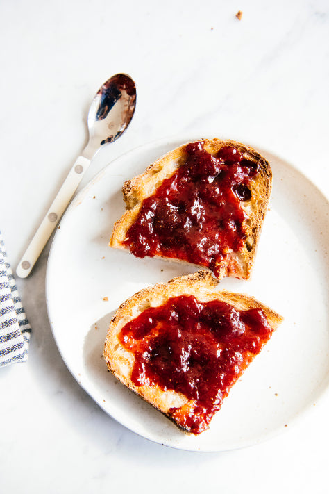 a slice of toast cut in half topped with cherries