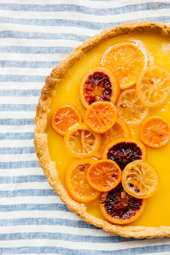 A homemade citrus tart topped with candied citrus slices