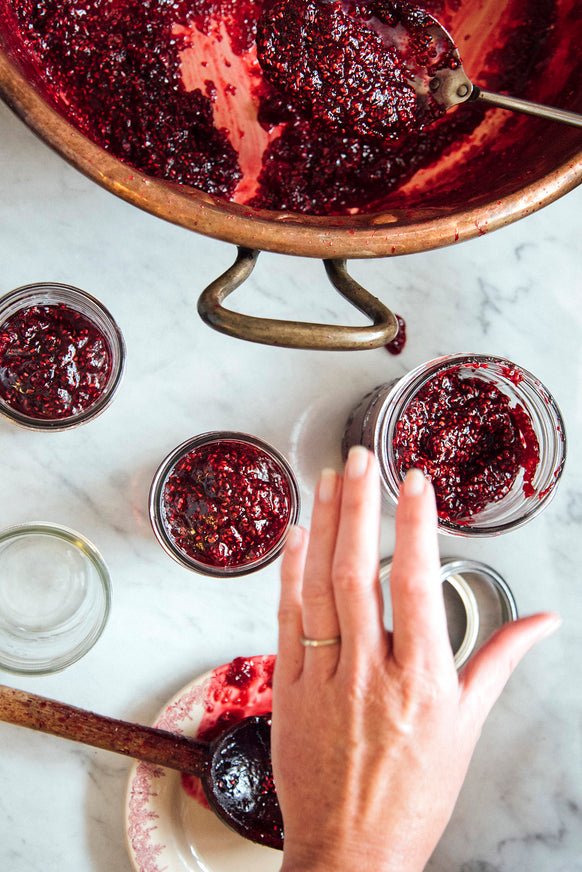 filling jam jars of preserves from a copper kettle