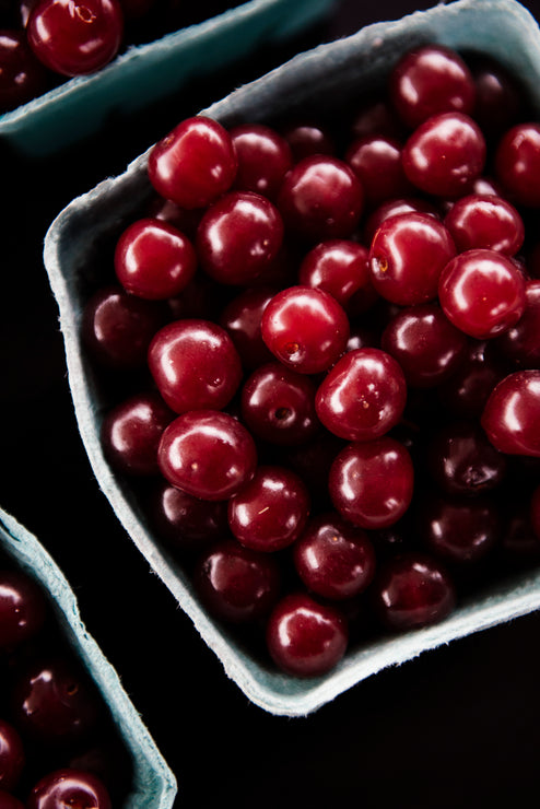 Load image into Gallery viewer, Close-up of red cherries in a blue fruit pint basket.