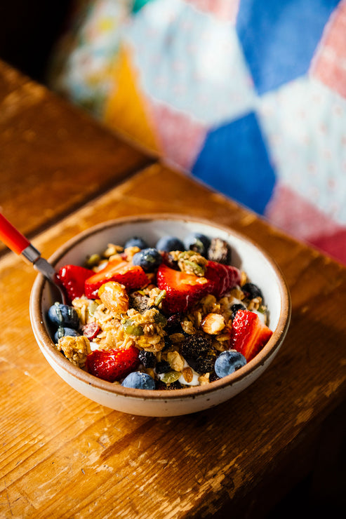 Load image into Gallery viewer, Bowl of Granola on a wooden table with fresh berries