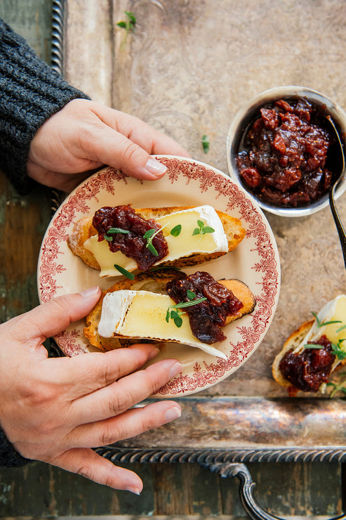 Load image into Gallery viewer, plated crostini topped with brie and holiday jam
