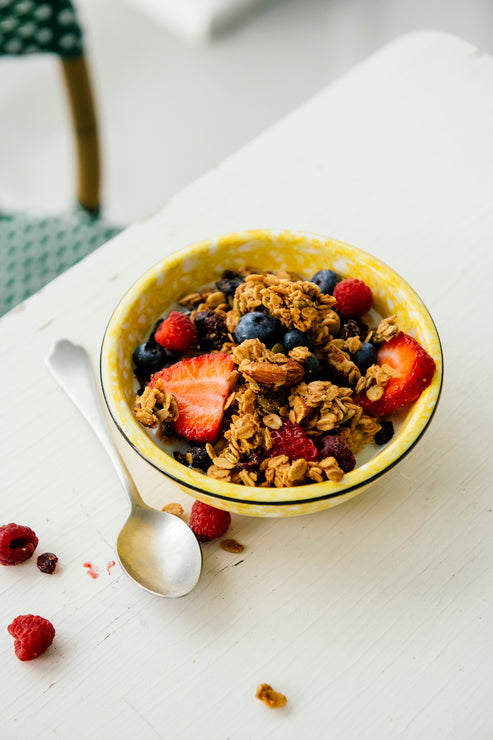 Load image into Gallery viewer, Bowl of granola with berries on a white surface