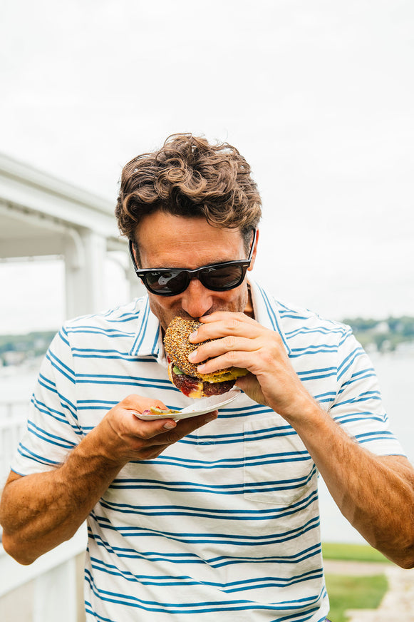 Man enjoying a classic cheeseburger with American Spoon condiments.