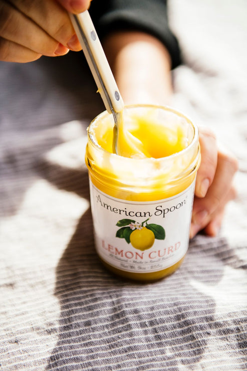 Load image into Gallery viewer, dipping into a jar of lemon curd with a spoon