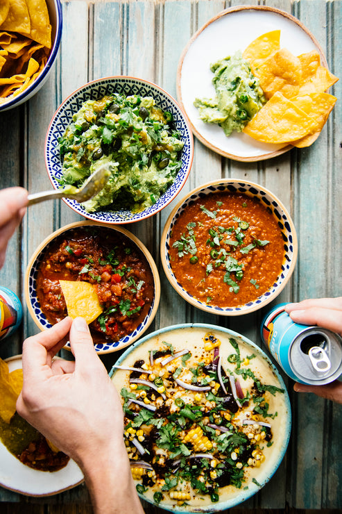 Load image into Gallery viewer, Dipping chips into of American Spoon Salsa, Queso with Dried Chili Salsa and fresh guacamole
