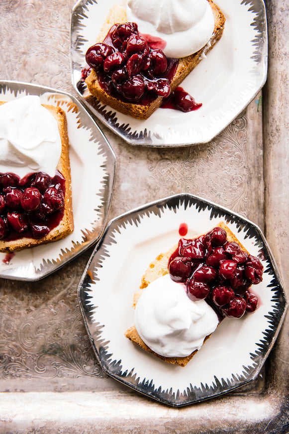 Slices of Pound Cake topped with Christmas Cherries and homemade whipped cream