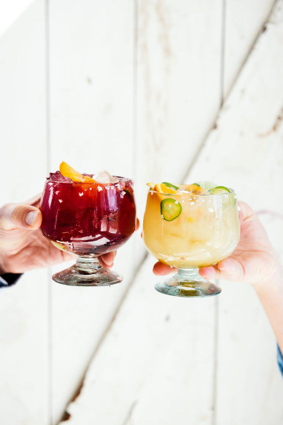 A glass of Margarita Mix and Cherry Margarita Mix in a cheers