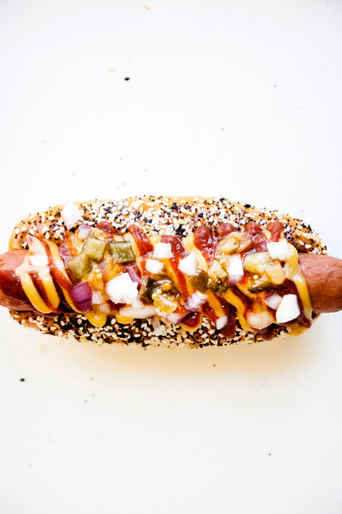 Load image into Gallery viewer, A hot dog topped with peppers, onion, and American Spoon mustard