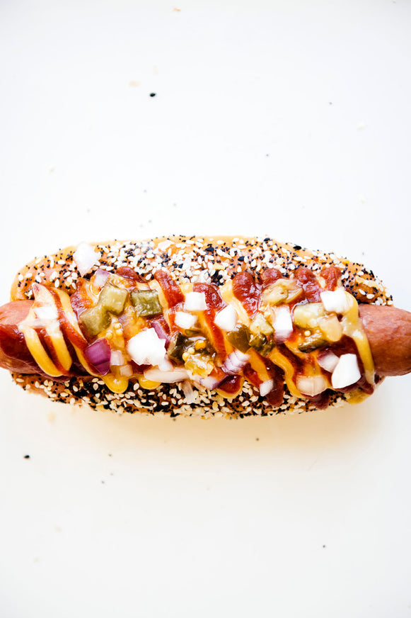 A hot dog topped with peppers, onion, and American Spoon mustard