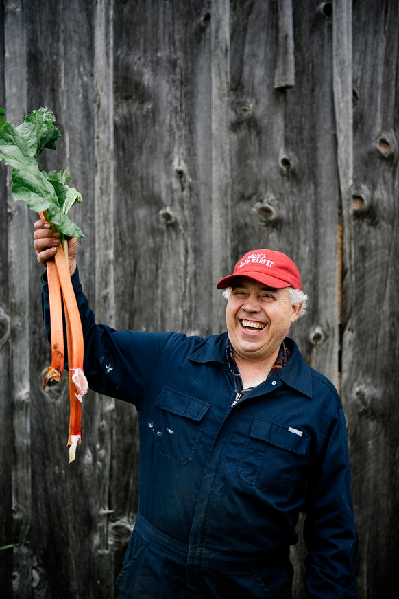 Bill McMaster of Bill's Farm Market holding stalks of rhubarb