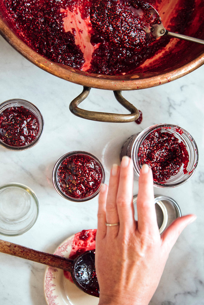 Filling jars of Red Raspberry Butter from a copper kettle
