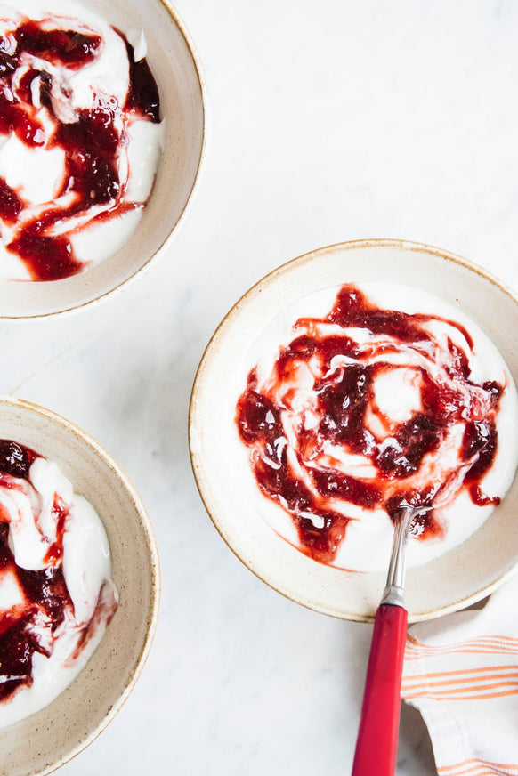 Three bowls of yogurt with preserves mixed in