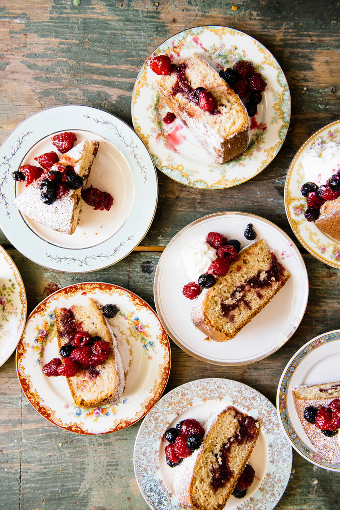 several dessert plates with slices of cake and raspberry jam