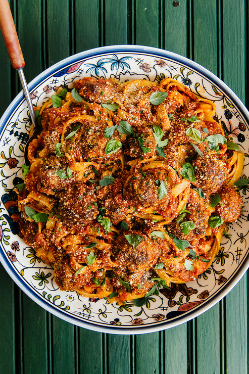 Load image into Gallery viewer, Family style pasta and meatballs with fresh basil.

