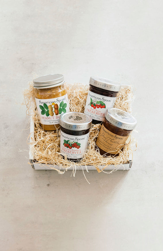 A gift box with peanut butter, fruit preserves and honey