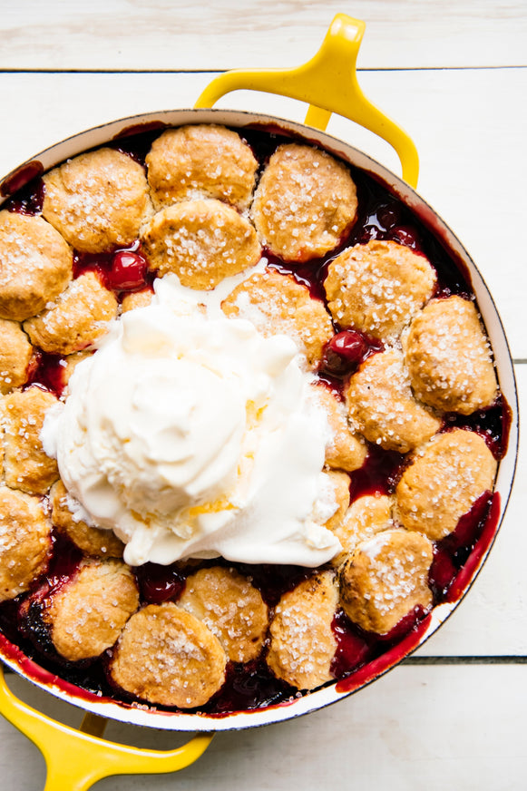 Cherry cobbler with homemade biscuits and whipped cream
