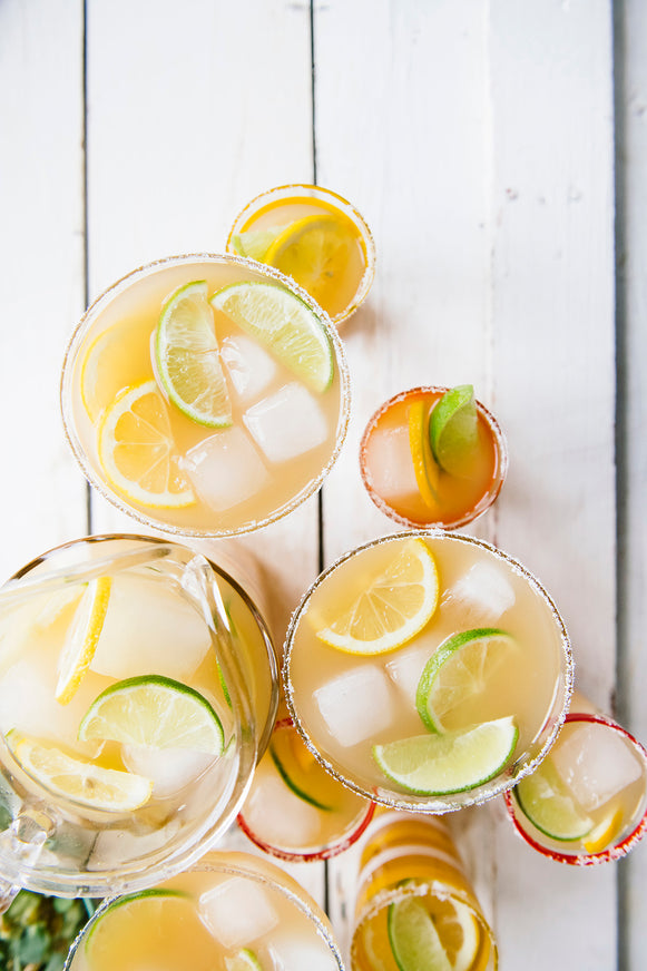 Margaritas garnished with lemons and limes.