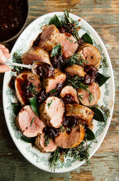 Load image into Gallery viewer,  a platter of sliced roast pork with holiday jam being spooned over it
