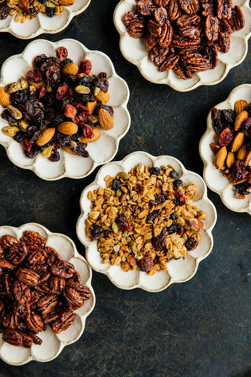 Load image into Gallery viewer, small scalloped plates full of granola and nut mix
