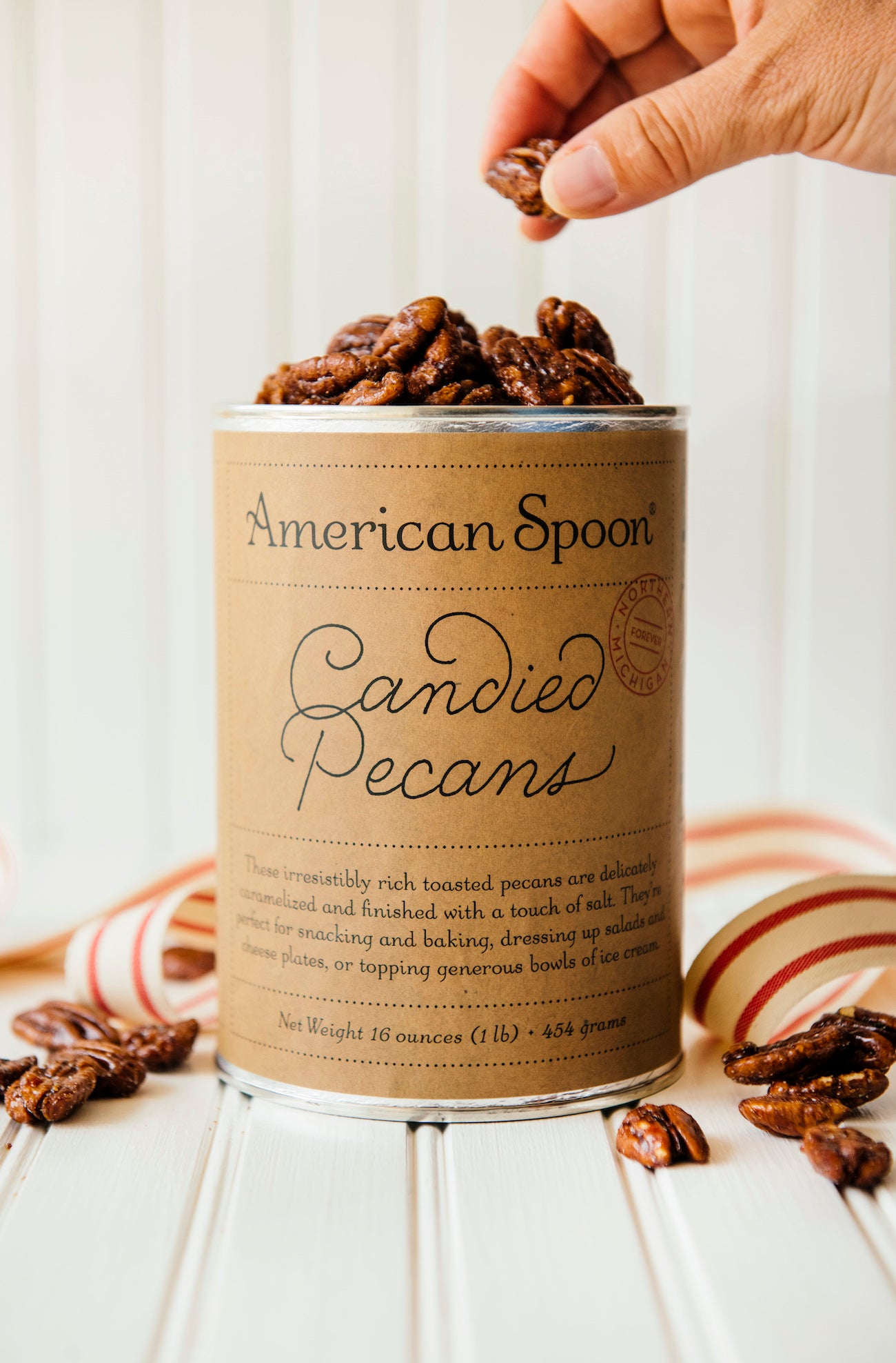 an open 16 oz canister of candied pecans
