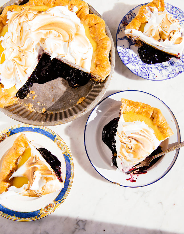 a sliced lemon meringue and blueberry pie