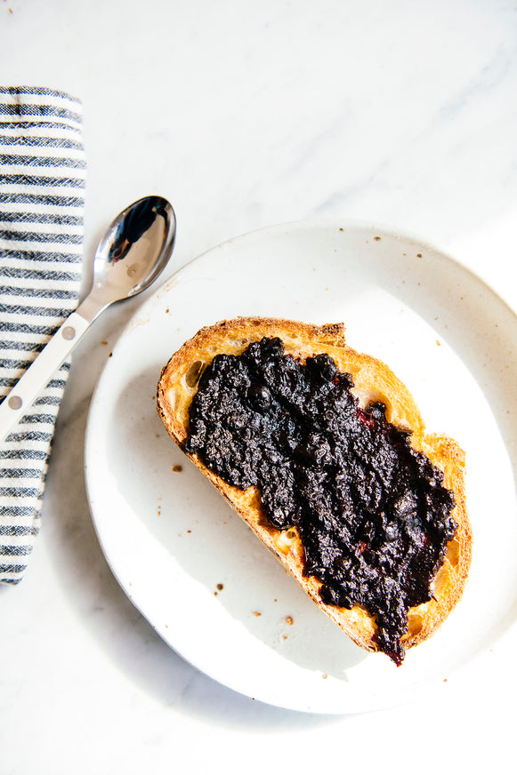 blueberry preserves on toast on a white plate