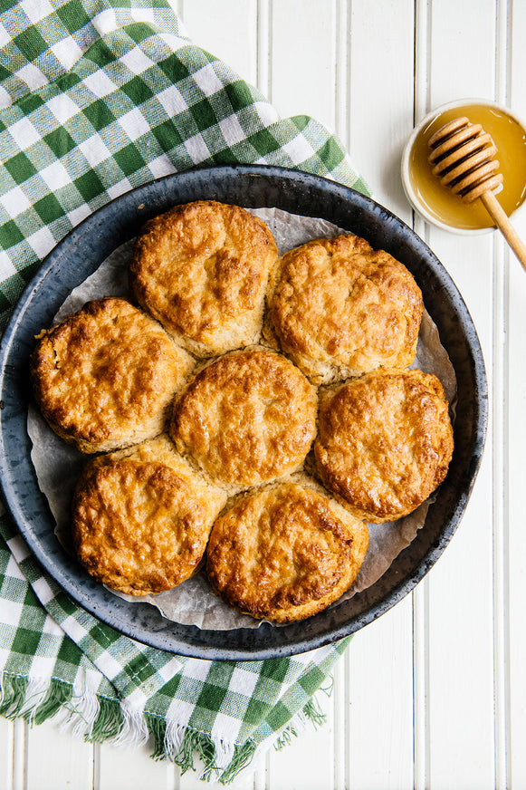 Skillet of seven homemade biscuits with honey.