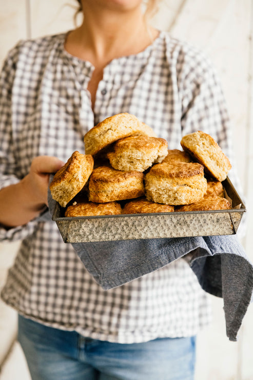 Load image into Gallery viewer, Woman holding a tray of homemade biscuits
