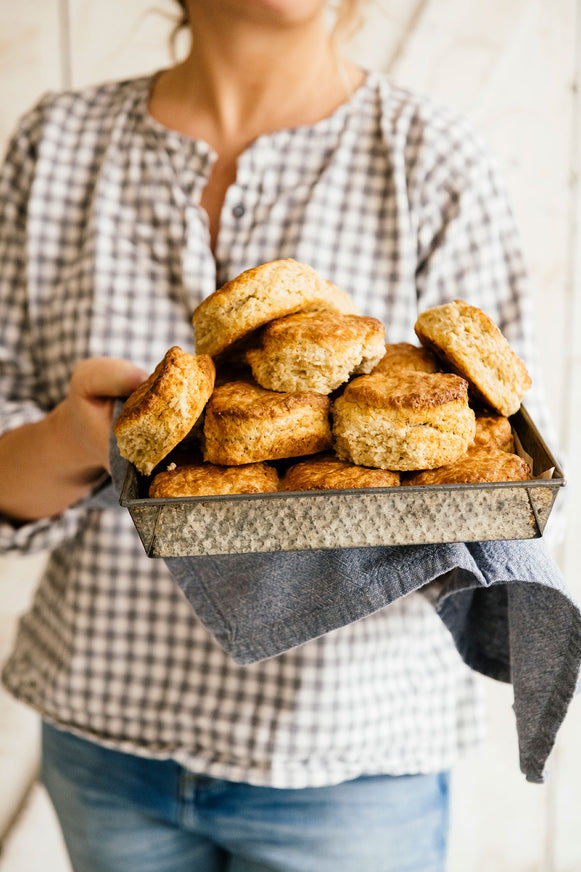 Woman holding a tray of homemade biscuits