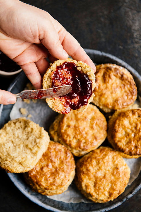 Load image into Gallery viewer, Skillet of homemade biscuits with preserves being spread over an open biscuit
