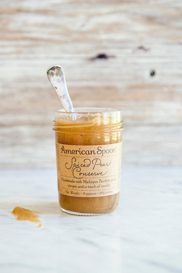 Jar of American Spoon Spiced Pear Conserve with a spoon on a wooden surface