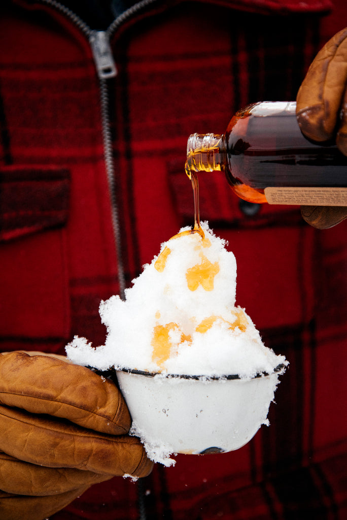 a cup of snow topped with maple syrup for a backyard sno cone