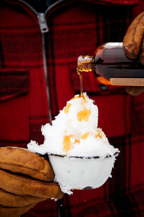 Load image into Gallery viewer, a cup of snow topped with maple syrup for a backyard sno cone
