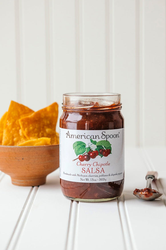 open jar of Cherry Chipotle Salsa with a small bowl of chips
