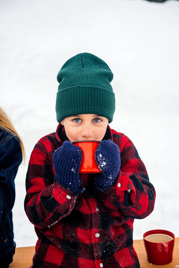 a young body drinking a mug of hot cocoa in the snow