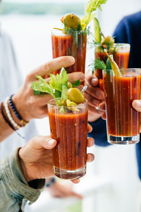 Load image into Gallery viewer, Friends holding up glasses of Bloody Mary Mix in a cheers
