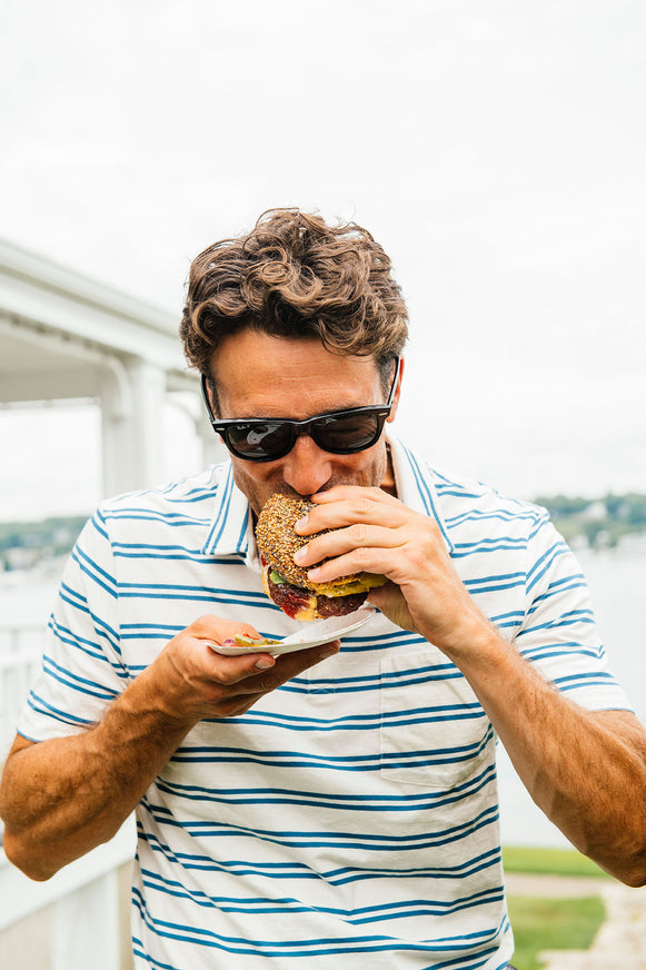 Man enjoying a classic cheeseburger with American Spoon condiments. 