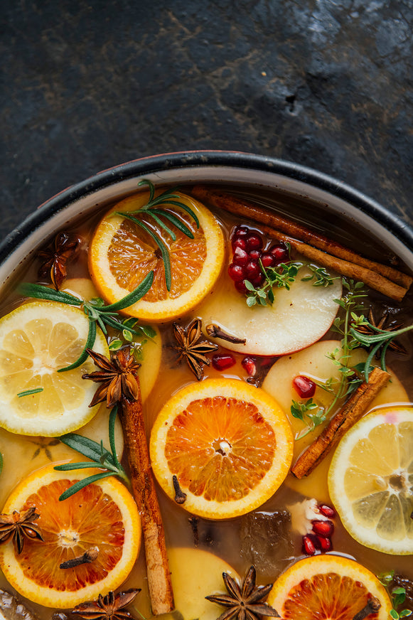 Spiced Cider Punch in a simmer pot with fresh citrus slices, cinnamon, star anise and pomegranates. 