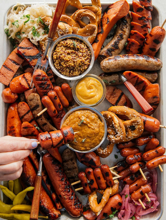 Load image into Gallery viewer, A platter of mixed grilled sausages with ramekins of mustard for dipping. 
